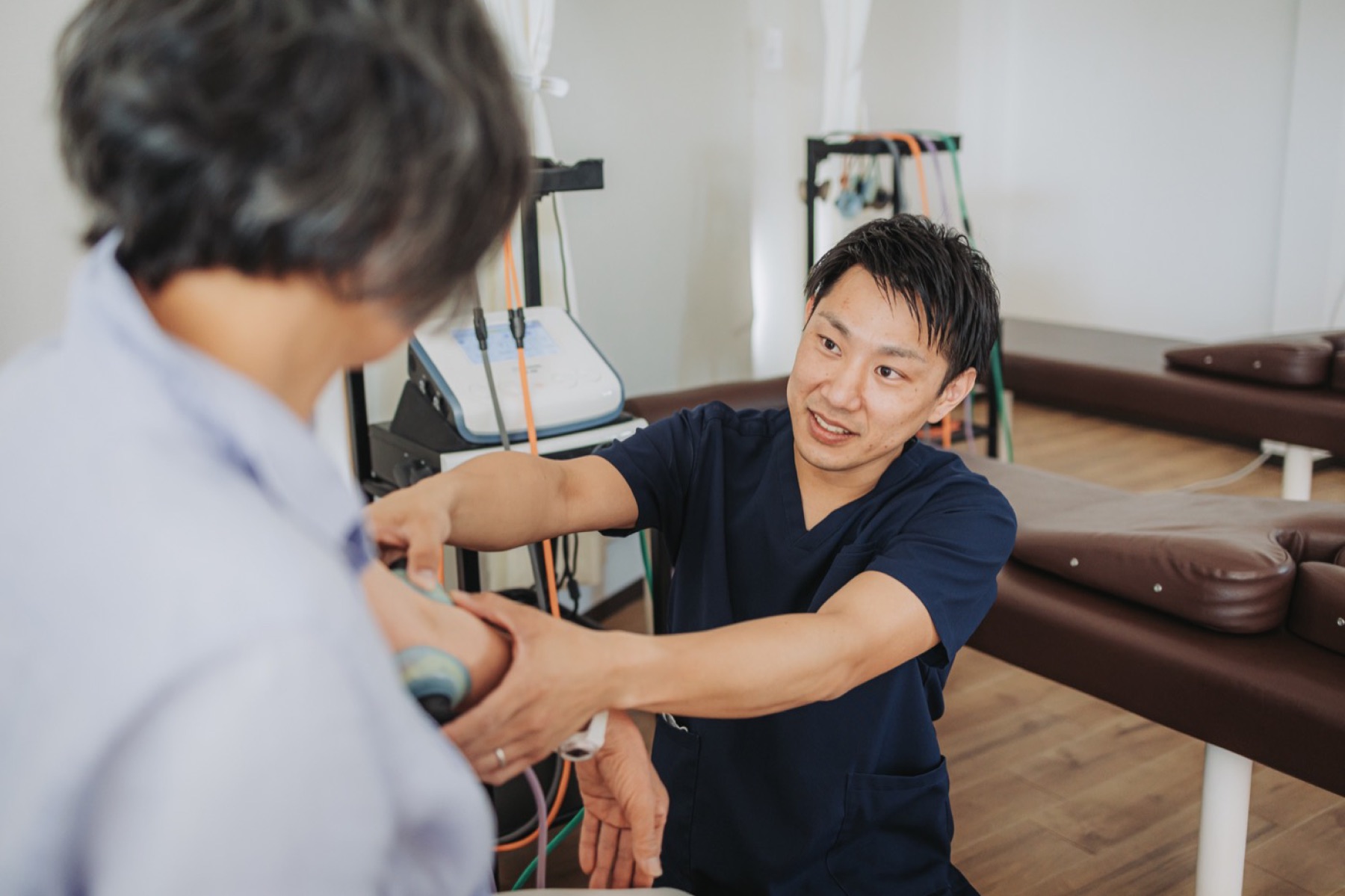 施術室で患者の腕にアプローチするたいじゅ接骨院の院長